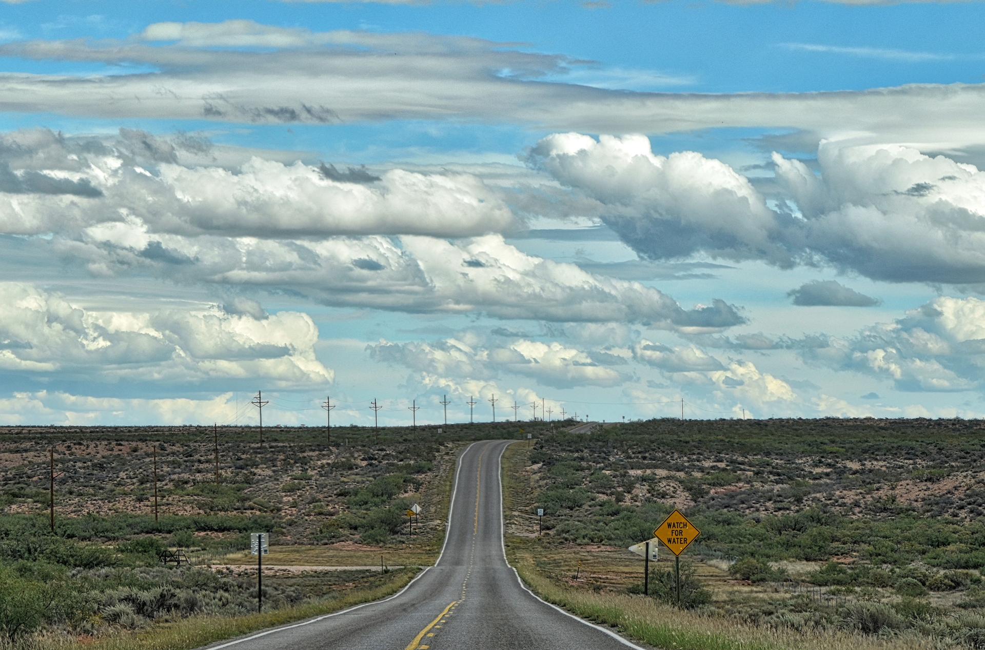 New Mexico open highway with "watch for water" sign